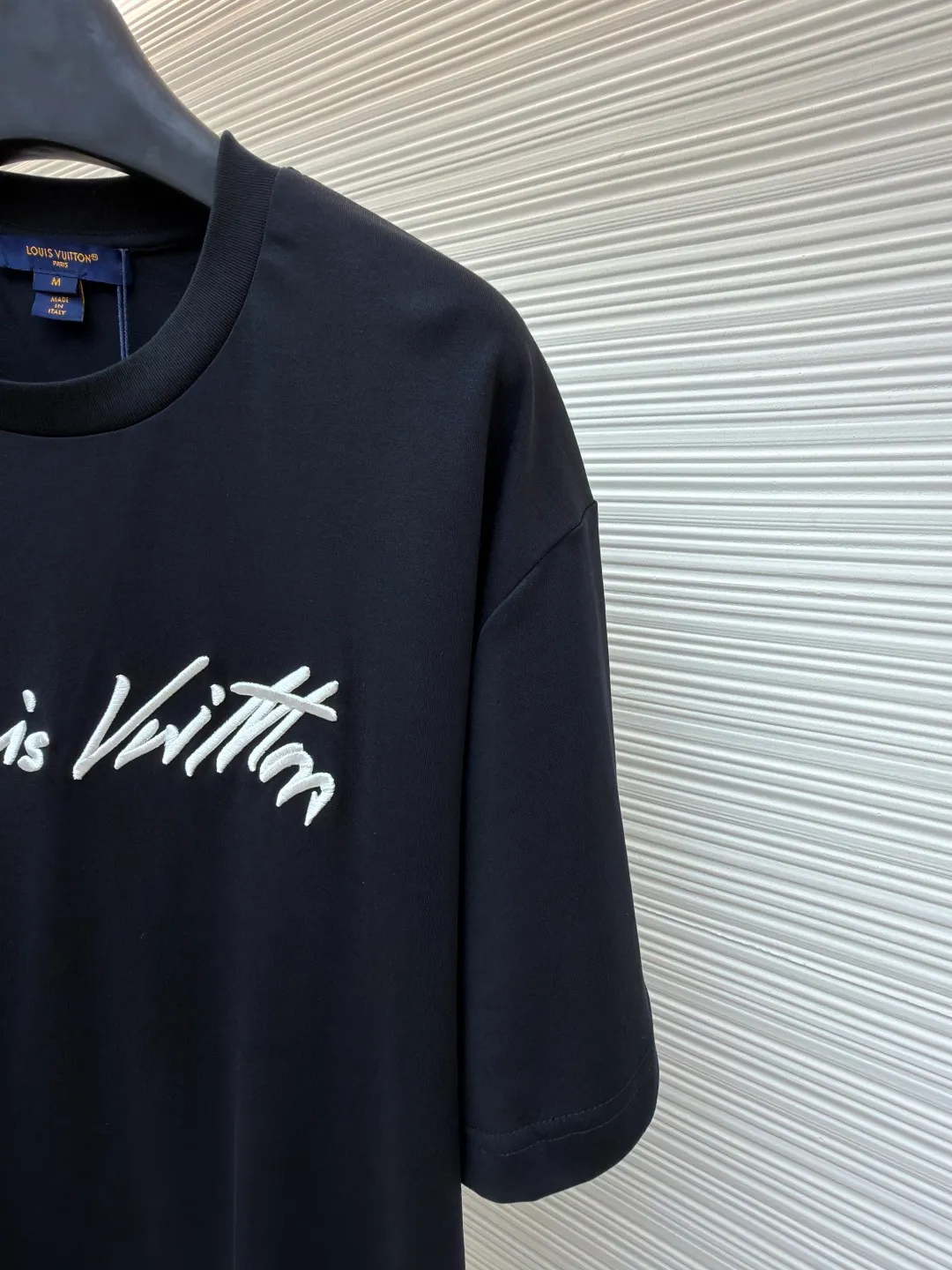LOUIS VUITTON round neck short sleeves with hand lettering embroidery ●Item number: 1681408-X95 ●Material: long-staple cotton fabric ●Technology: embroidery production ●Color: black ●Version: fitted version ●Weight: about 230 grams ●Size: S-M-L-XL ●Description: Restore 60S single yarn double-sided long-staple cotton, weight 170g; with 32S 1×1 thread, 300g. After being treated with liquid ammonia, it looks like a water-gloss machine. The cloth surface is smooth and has a clear texture, with a slight luster and strong texture. The cotton fiber length of the fabric is long. The advantage of this feature is that after being spun into yarn, the surface of the yarn is smoother, less rough and has a delicate feel. The thin and long features give it a flexible texture, soft skin feel and fabric luster. The front side shows the thickness changes of 3D handwritten font embroidery handwriting strokes and the design pattern after the continuous strokes are simplified; the three-dimensional effect is achieved through multi-layer embroidery threads, filling materials and special stitching methods. Jagged edges are prone to appear on curves and corners; add foam embroidery to the bottom layer of the embroidery and then cut off the excess to form a three-dimensional bulge and improve the smoothness of the lines. Standard H hanging fit with shoulder-length design. The vertical version emphasizes that the width of the shoulders, waist, and hem are basically the same, and it is simple and loose. The short sleeves are tailored to fit the body of the wearer. At the same time, the neckline, cuffs and hem of the short sleeves are all designed with double lines. The overall wiring is straight and delicate, the fabric is comfortable and soft, and the color is consistent without color difference. It can be matched with the same style to create a fashionable look and control various occasions. Customized accessories, complete with three standards, same style for men and women!